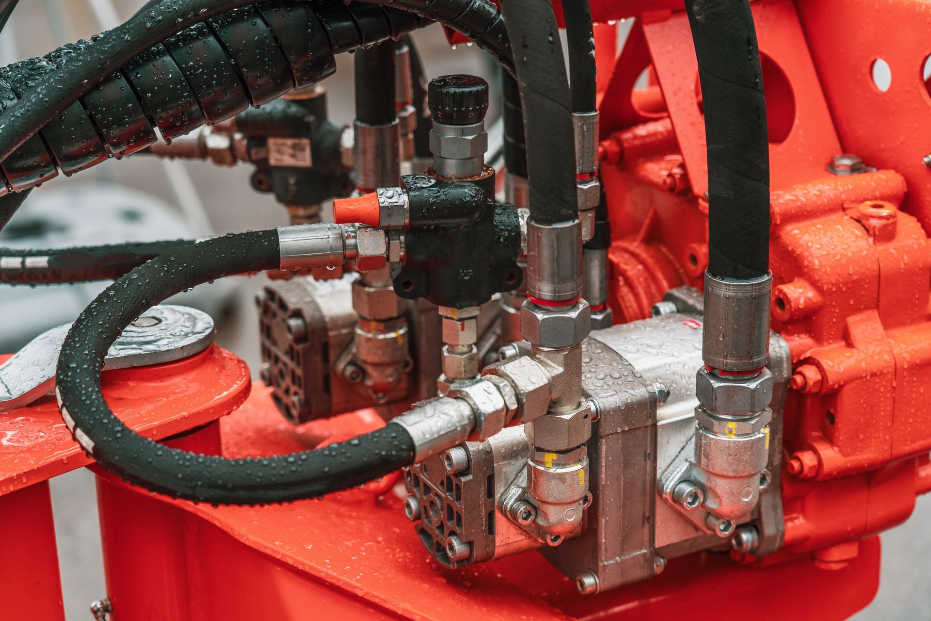 Hydraulic power unit with mechanical valve, pipes, and connections on a heavy industrial machine.