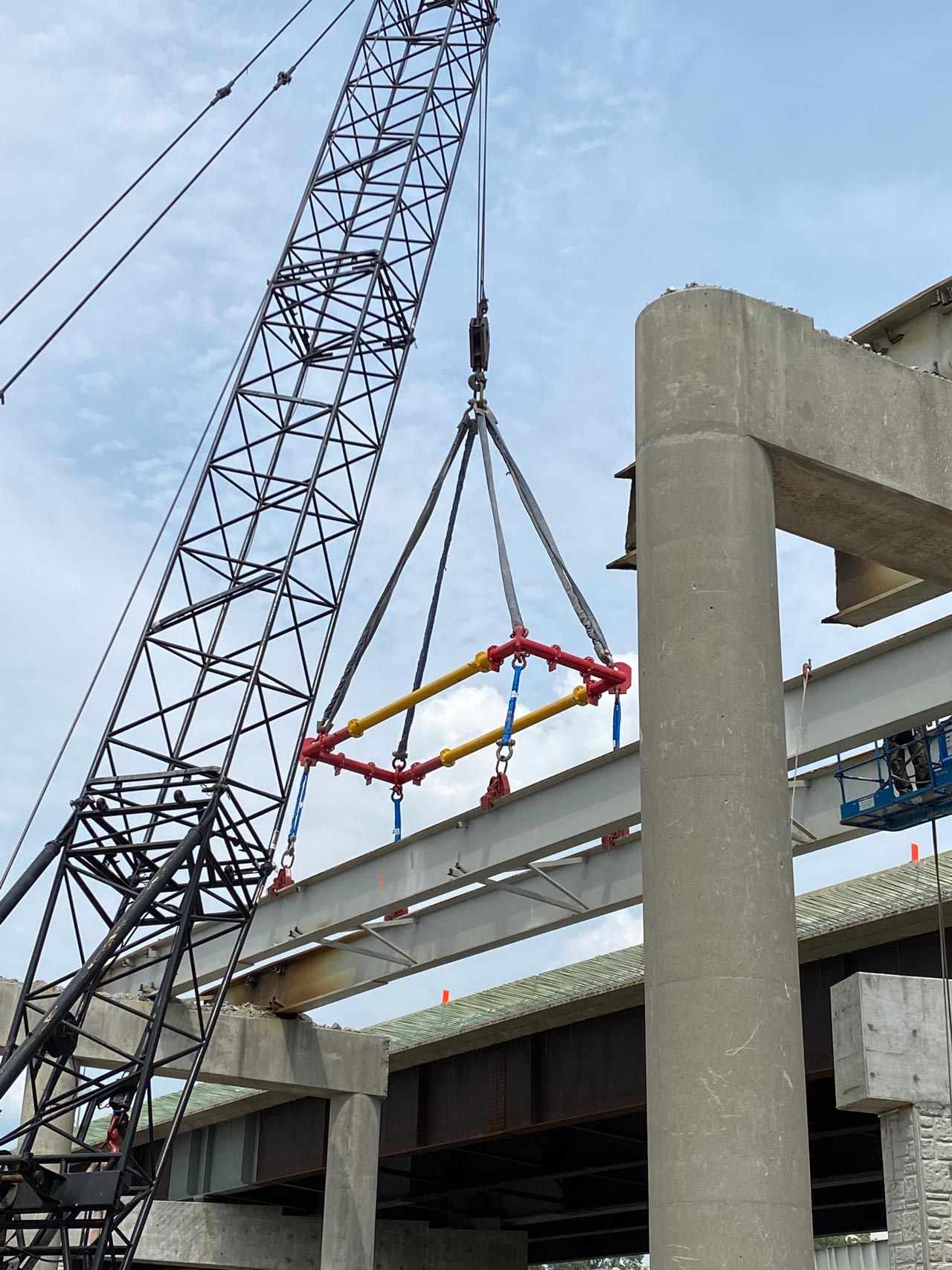 A crane lifting a concrete beam during bridge construction.
