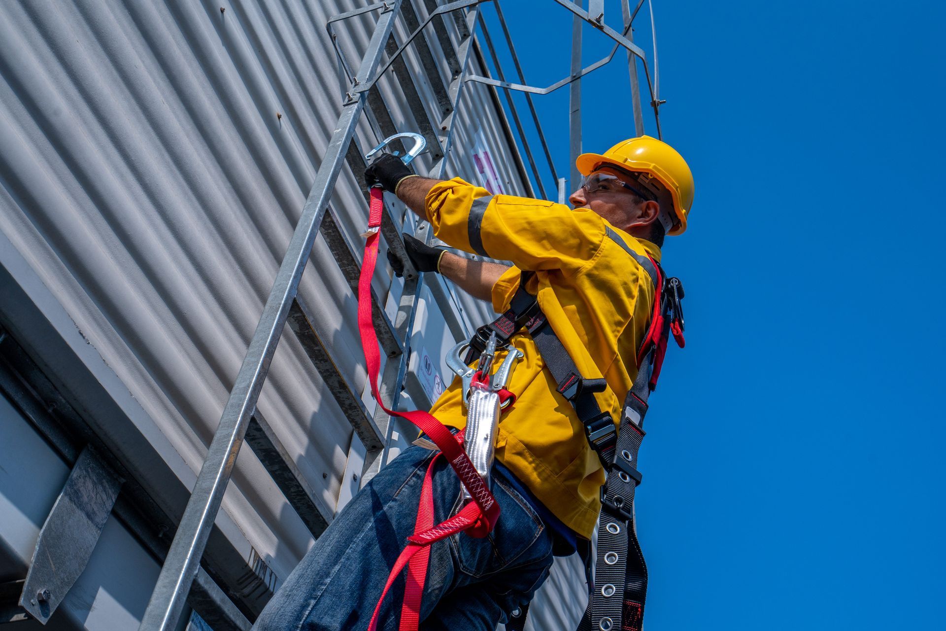 A construction worker uses a safety harness and belt while working on a high-rise site project.