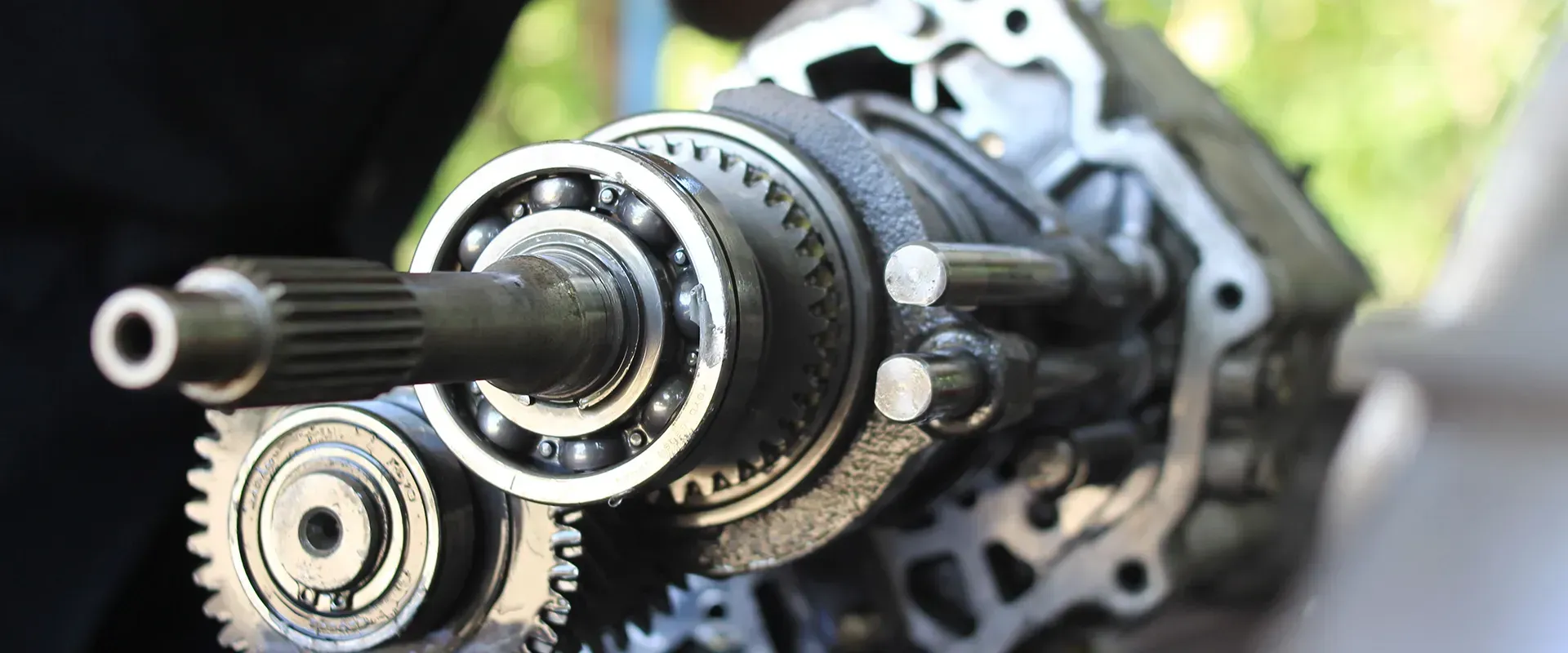 Close-up of a disassembled car transmission showing gears, bearings, and shafts.