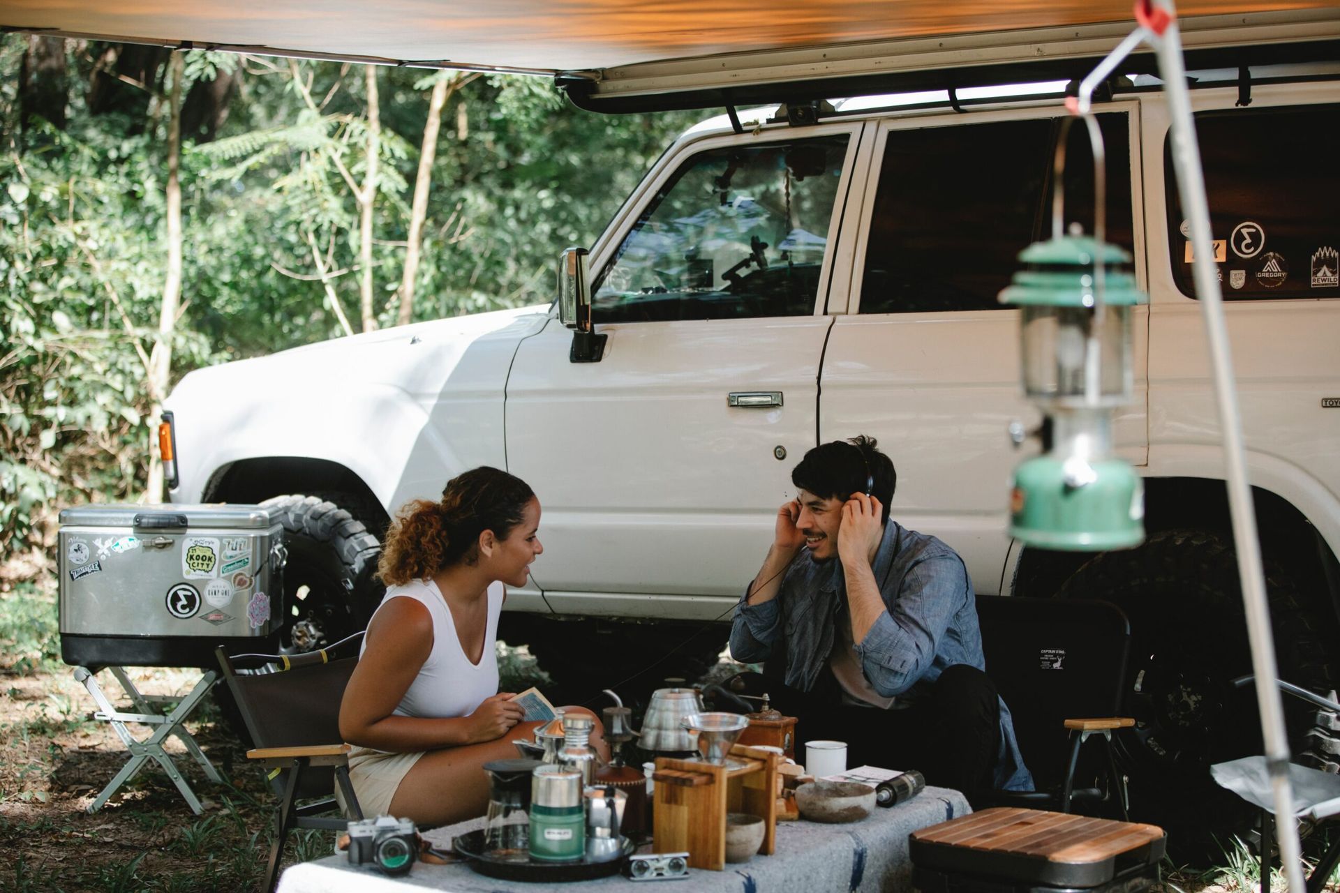 Two people camping with a car