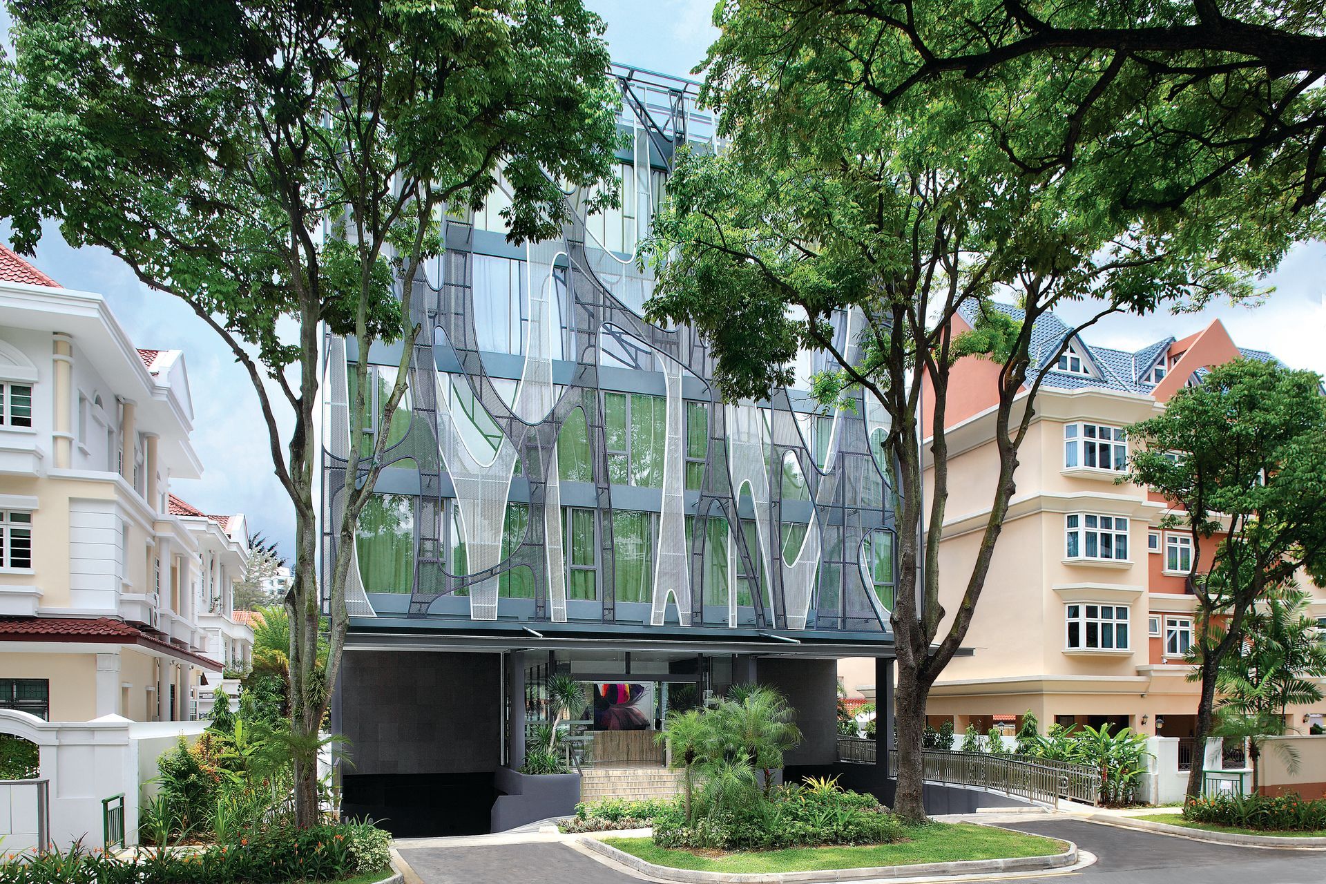 A building with a lot of windows is surrounded by trees