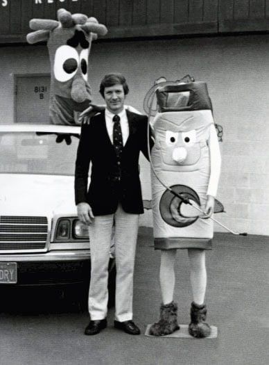 A vintage black and white photo of Chem-Dry founder Robert Harris with an early company mascot
