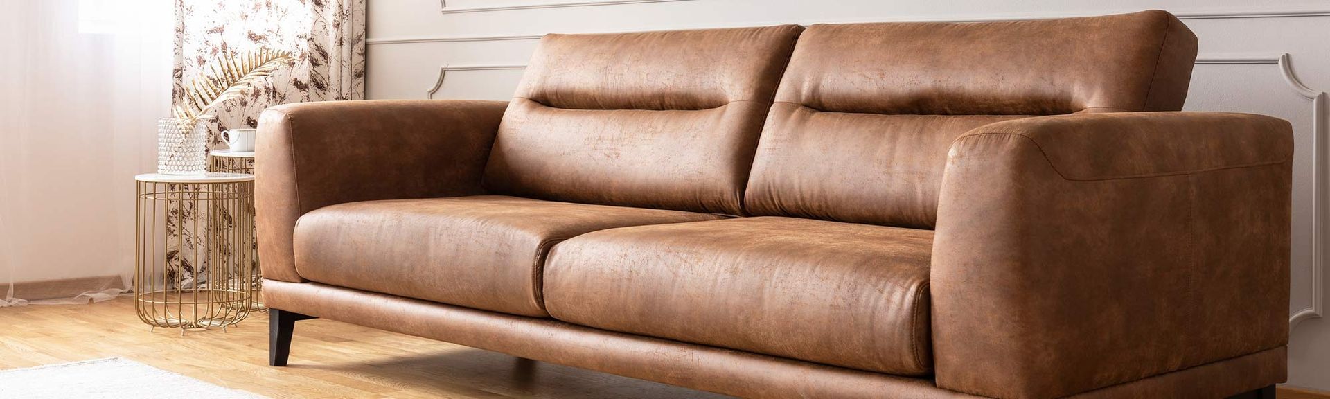 A brown leather couch in a living room setting.