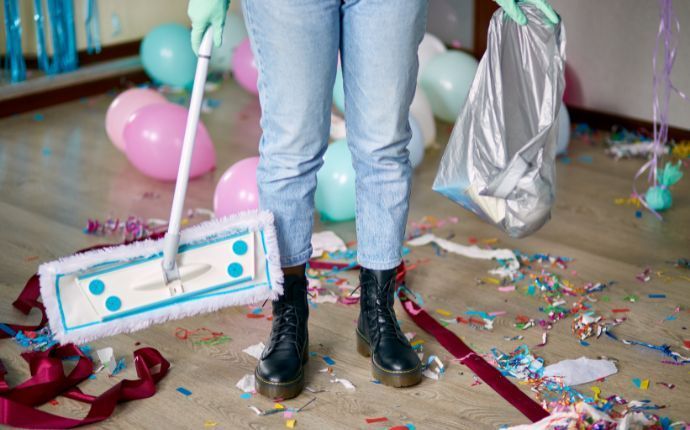 a woman deep cleaning a living room with holiday decorations scattered, 