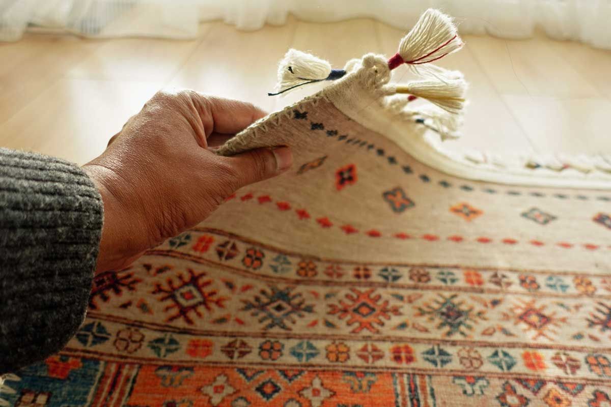 Two men from Chem-Dry unloading a rug from a white van. One carries the rug, while the other holds the van door.