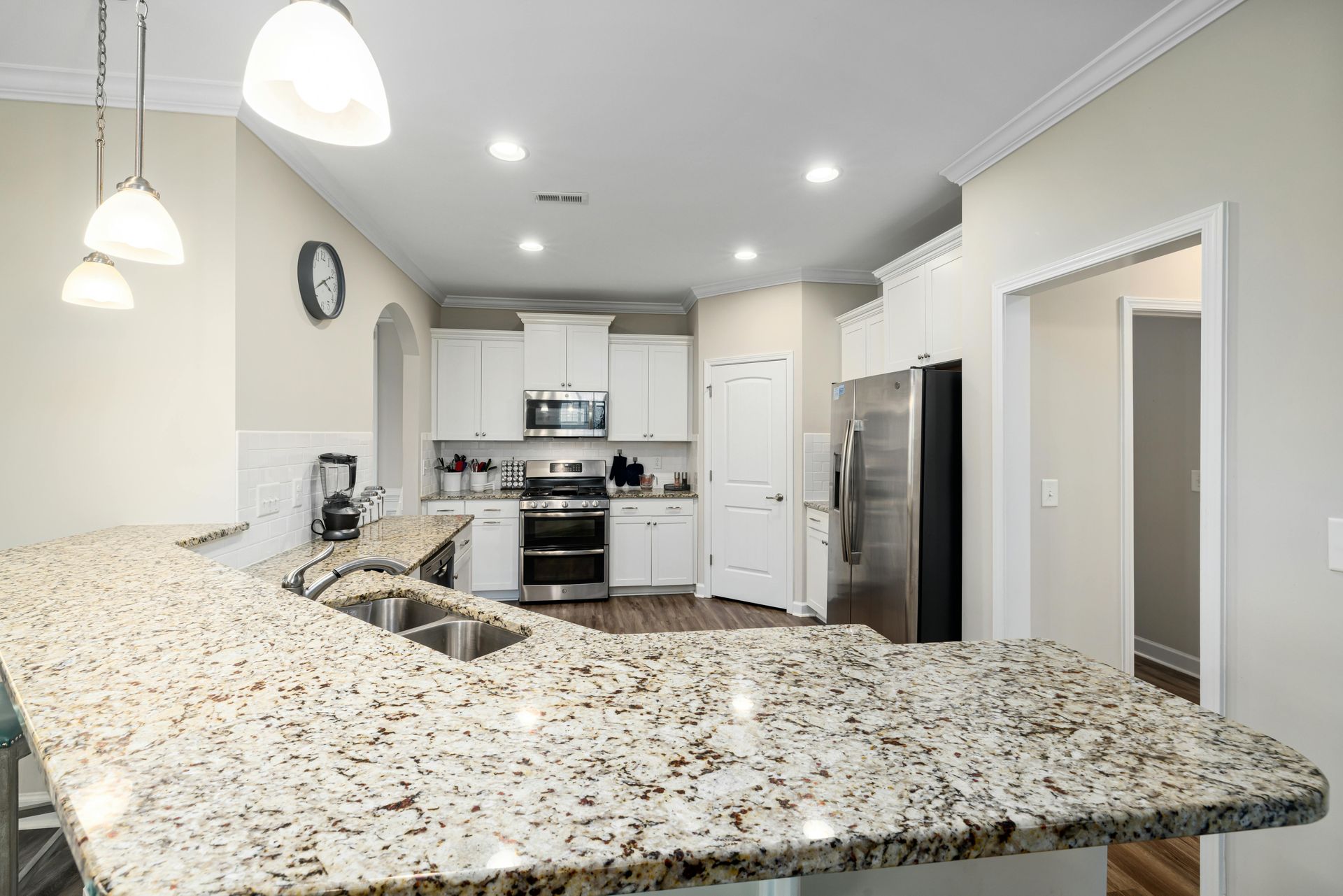 Kitchen with light countertops, white cabinets, and stainless steel appliances.