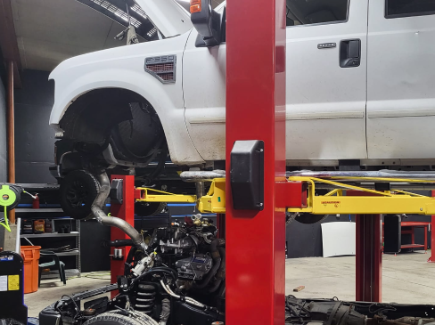 white truck on lift | Jay's Total Car Care