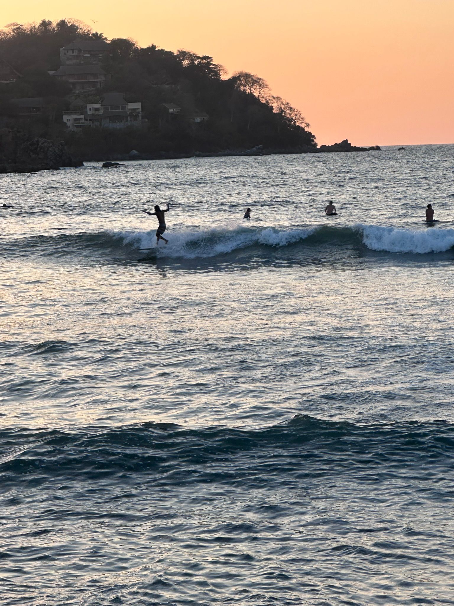 A person is riding a wave on a surfboard in the ocean.