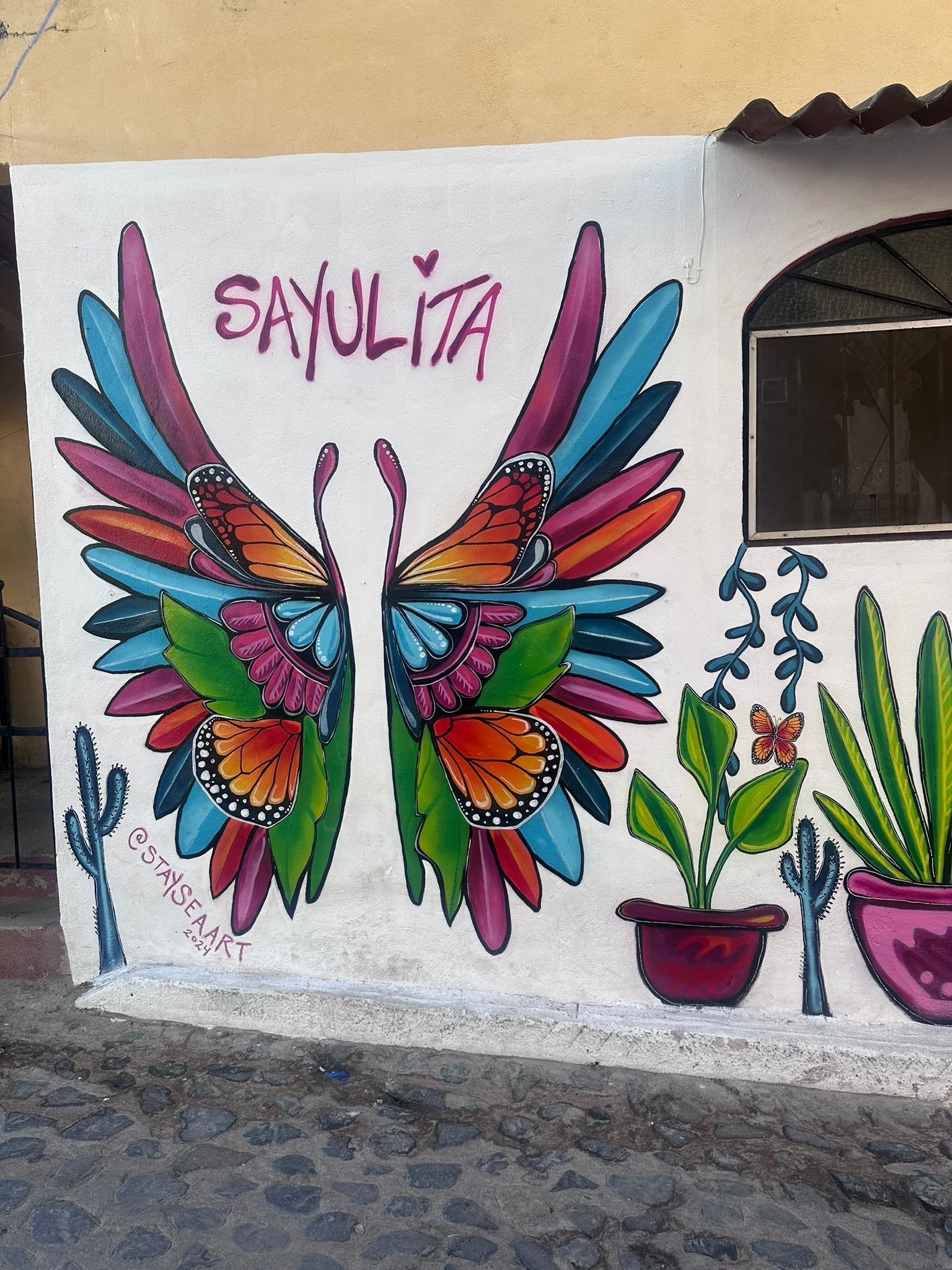 A mural of a butterfly with the name sayulita on it