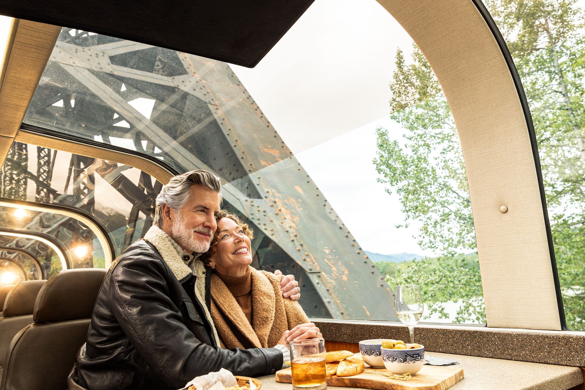 A man and a woman are sitting at a table on a train.