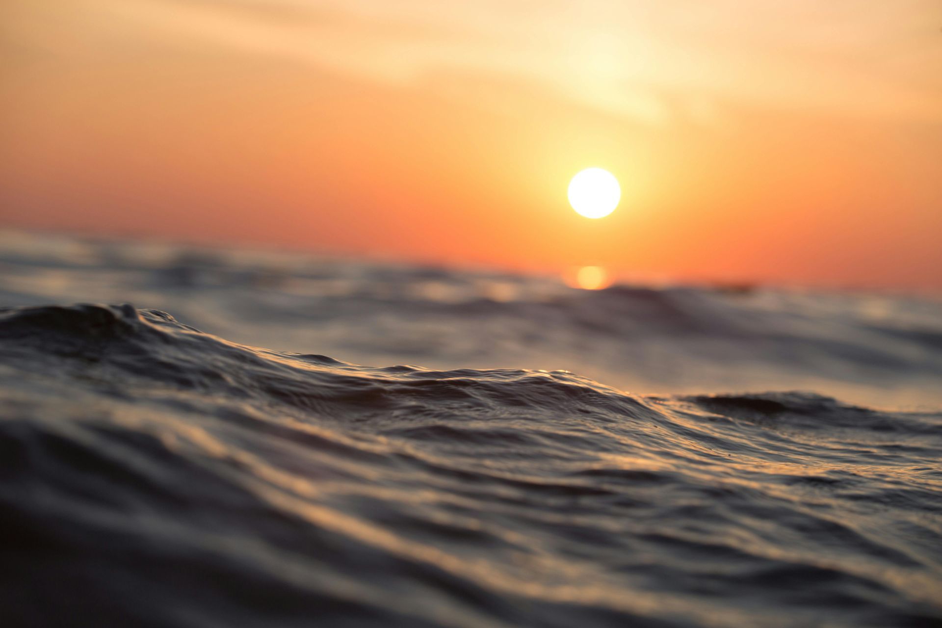 A close up of waves in the ocean at sunset.