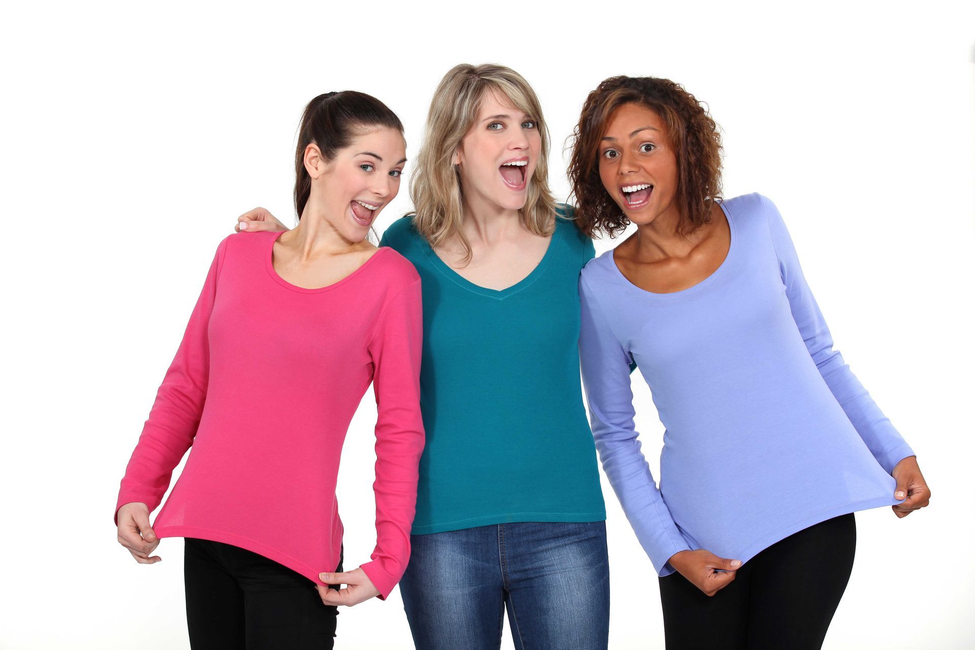 Three people wearing colored long-sleeved shirts, all smiling with mouths open.
