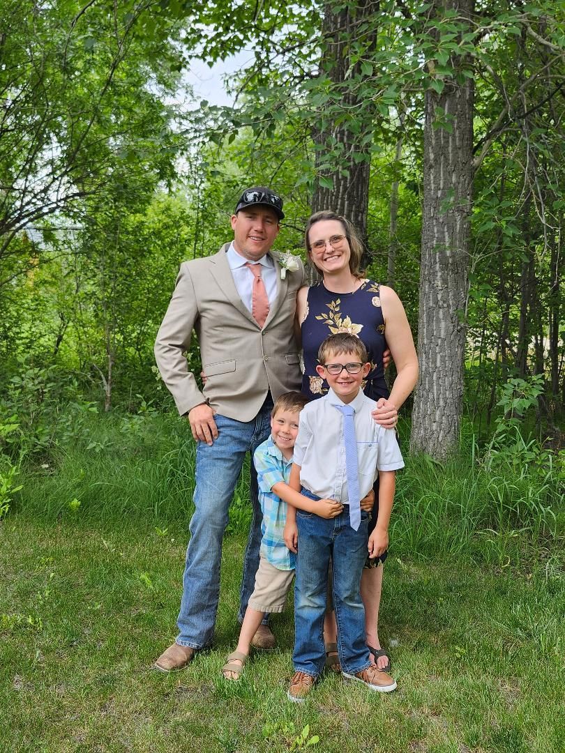 Four smiling women in light pink tops, arms around each other, in front of a cream background. Four smiling women in light pink tops, arms around each other, in front of a cream background.