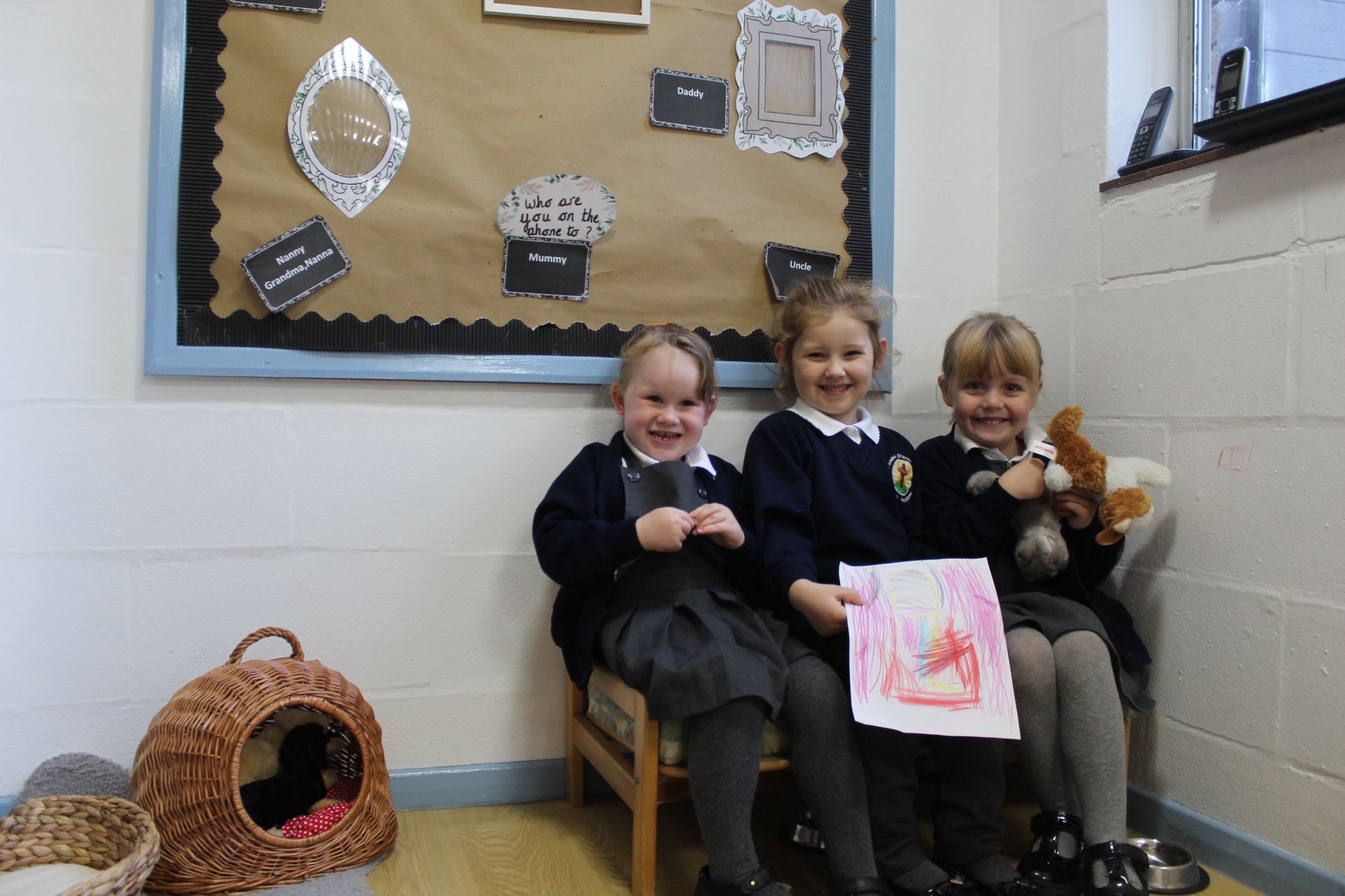 Two girls playing with a fishing game at a table in a classroom.