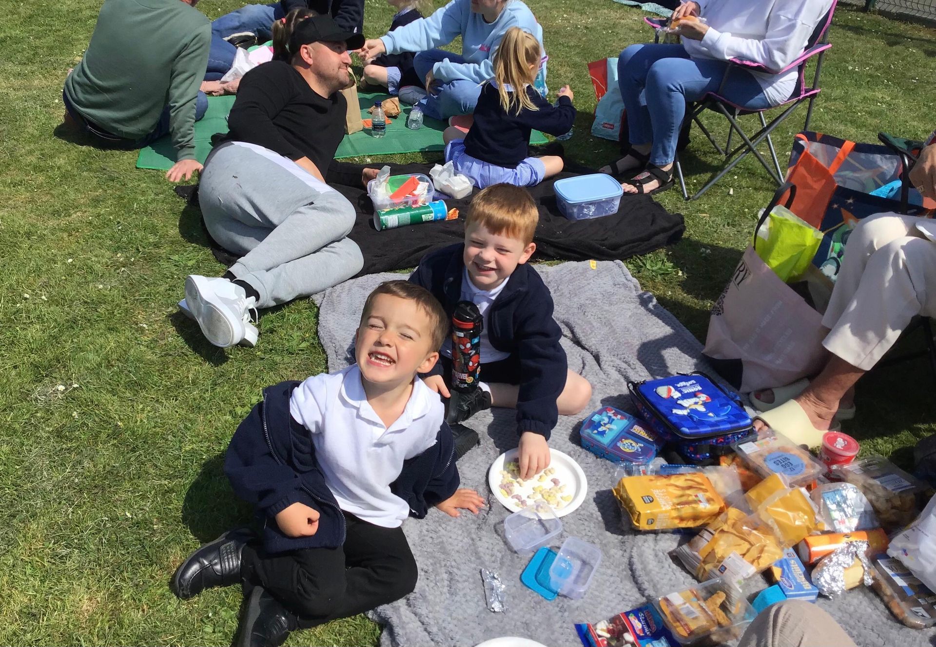 A group of children are having a picnic in the grass.