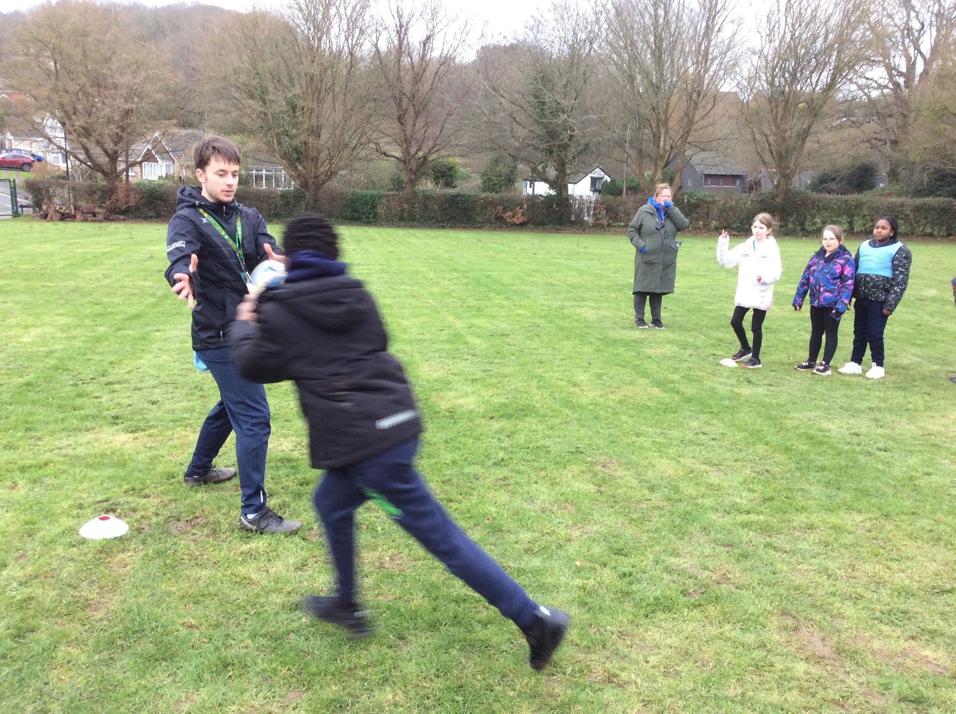 A group of children are playing in a grassy field.