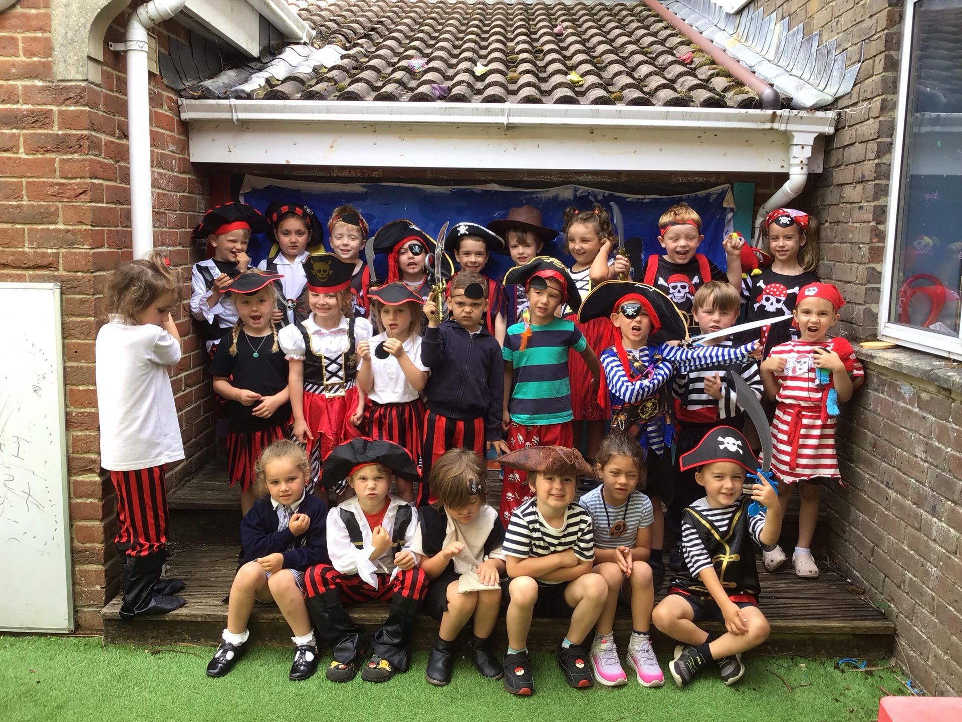 A group of children dressed in pirate costumes are posing for a picture.
