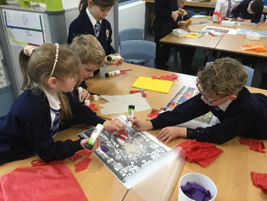 A group of children are sitting around a table making crafts