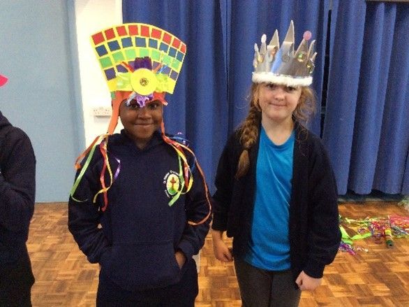 Two school children wearing colorful hats are standing next to each other