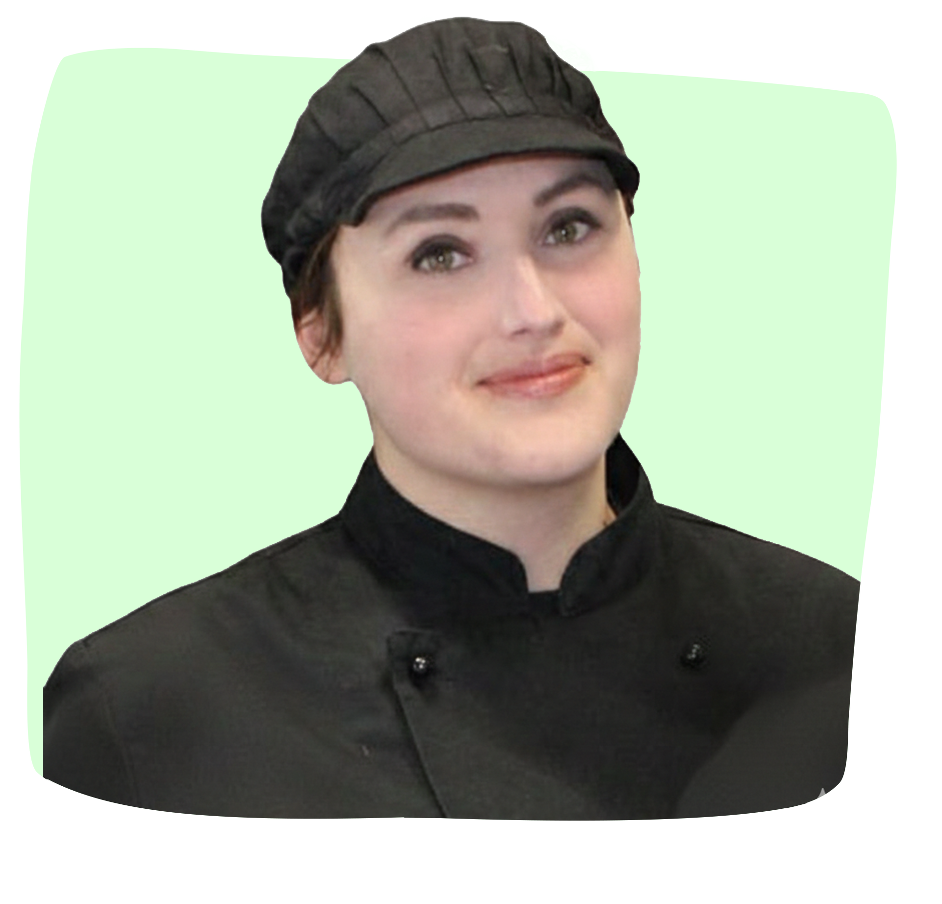 Cuoco in uniforme nera e berretto, sorridente, su sfondo verde chiaro.