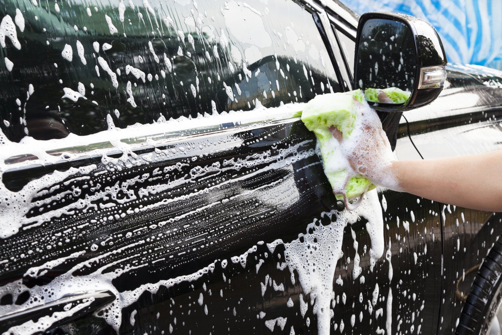 A car being hand washed during a detail