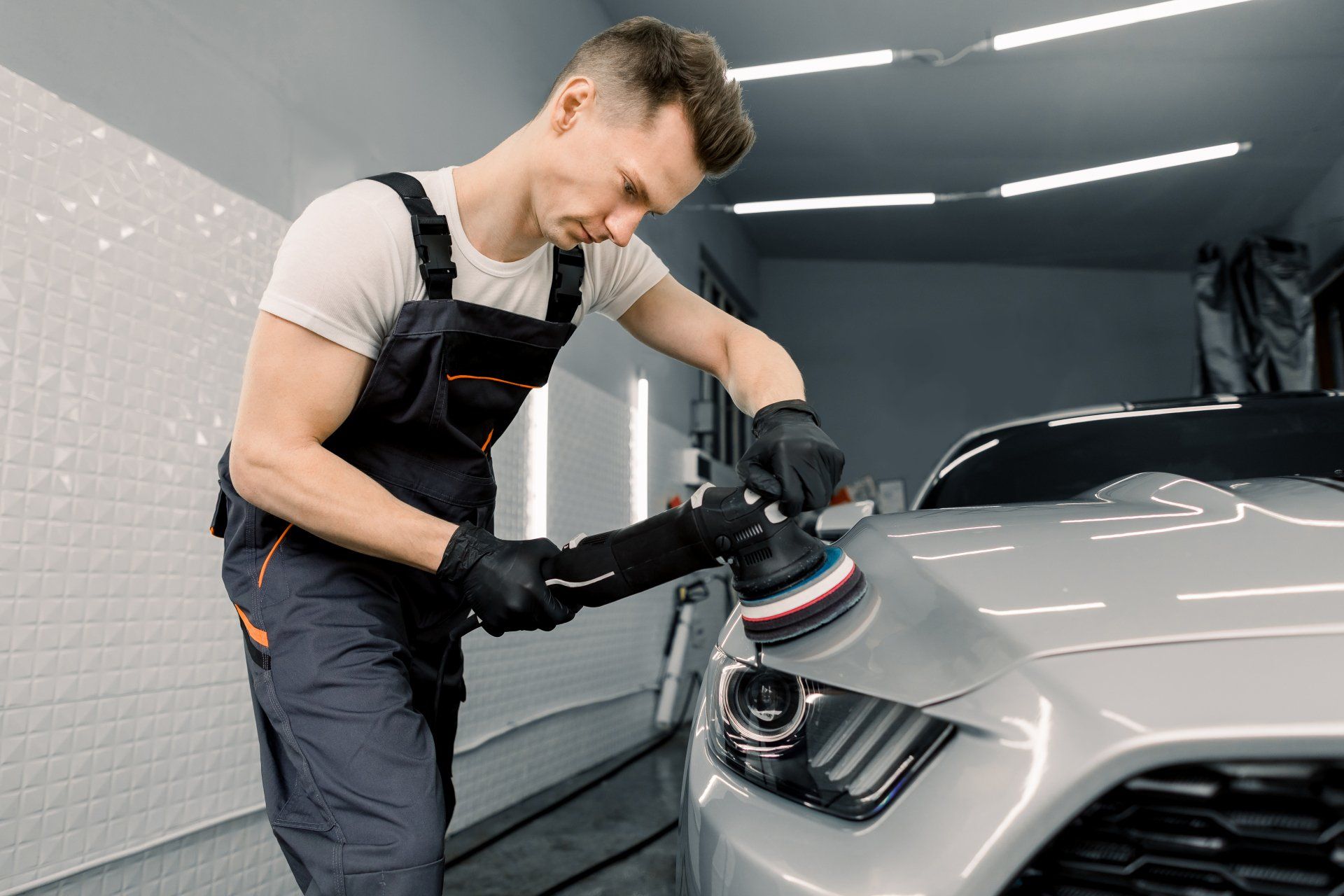 Man buffing a silver sports car