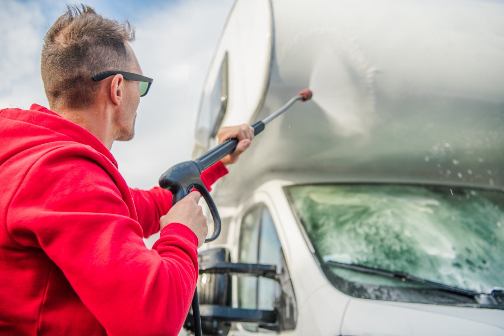 A man power washing an RV