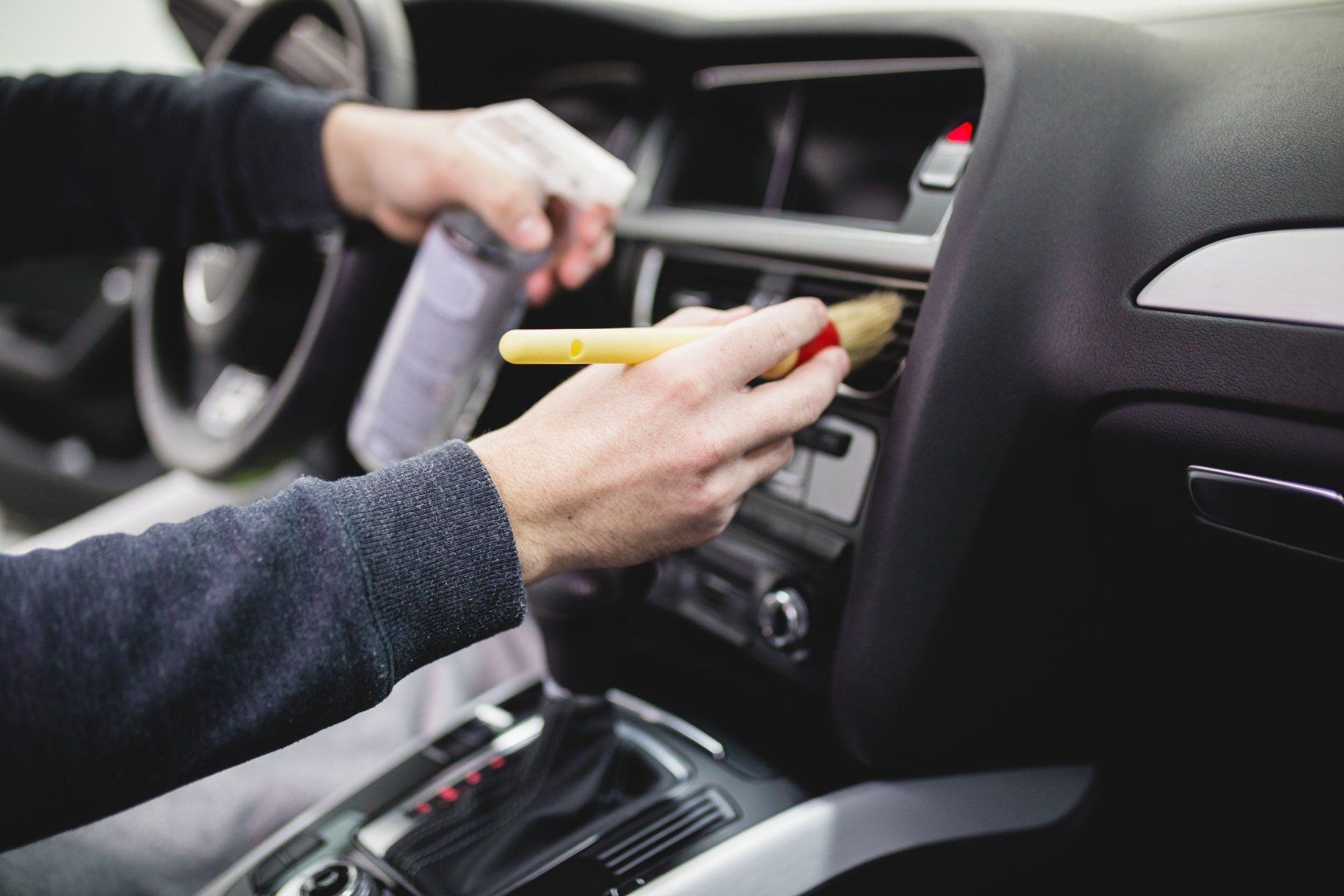 worker detailing the inside of a car