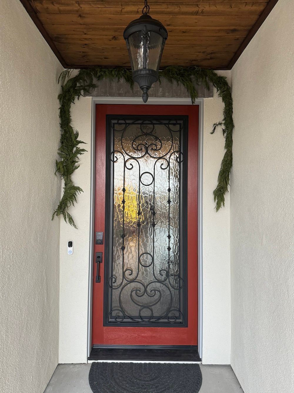 A red door with a black wrought iron frame