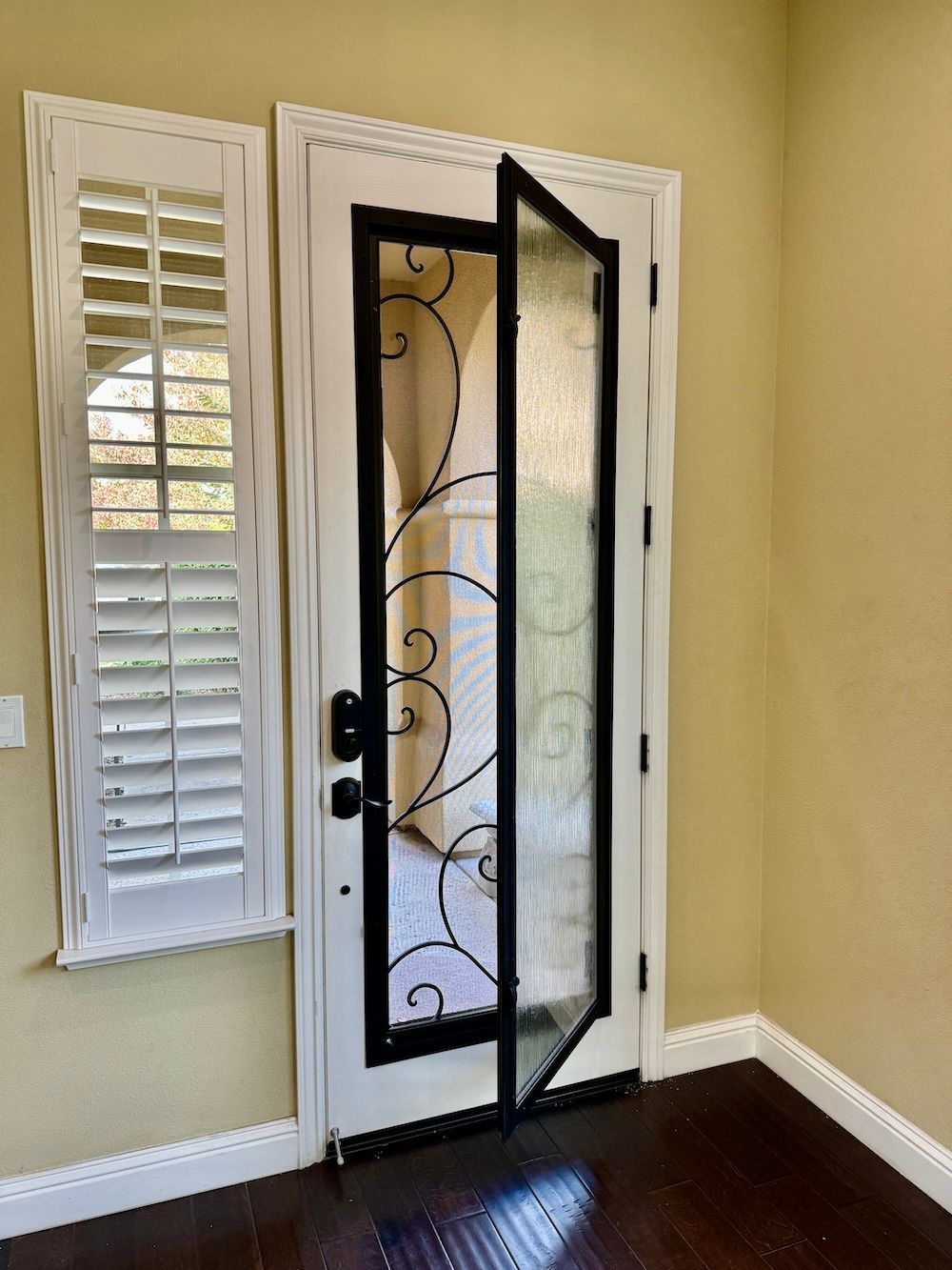 A white door with a black frame and shutters in a room.