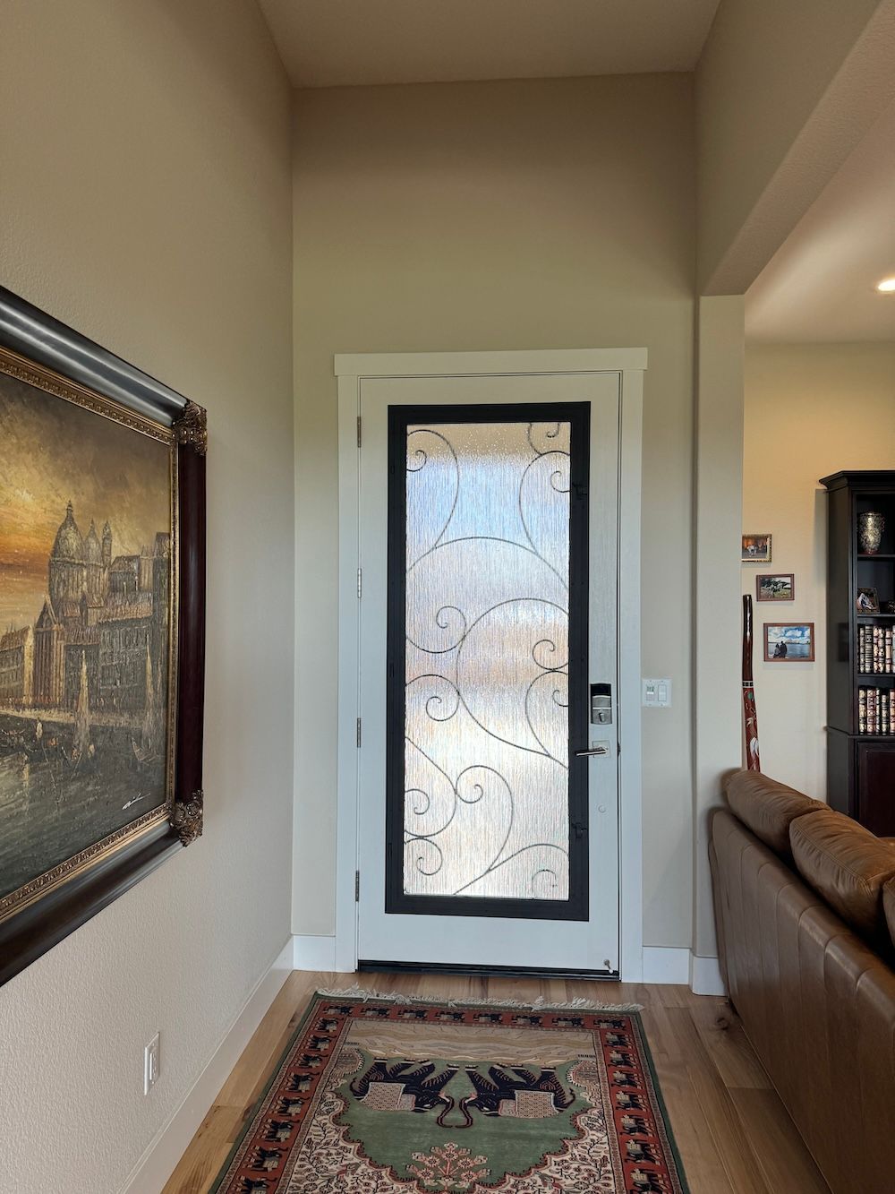 A hallway with a door and a rug in a living room.
