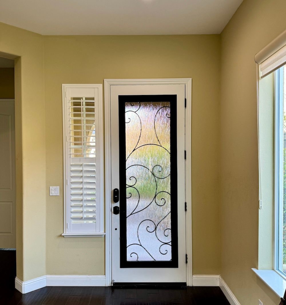 There is a door with a stained glass window in the middle of the room.