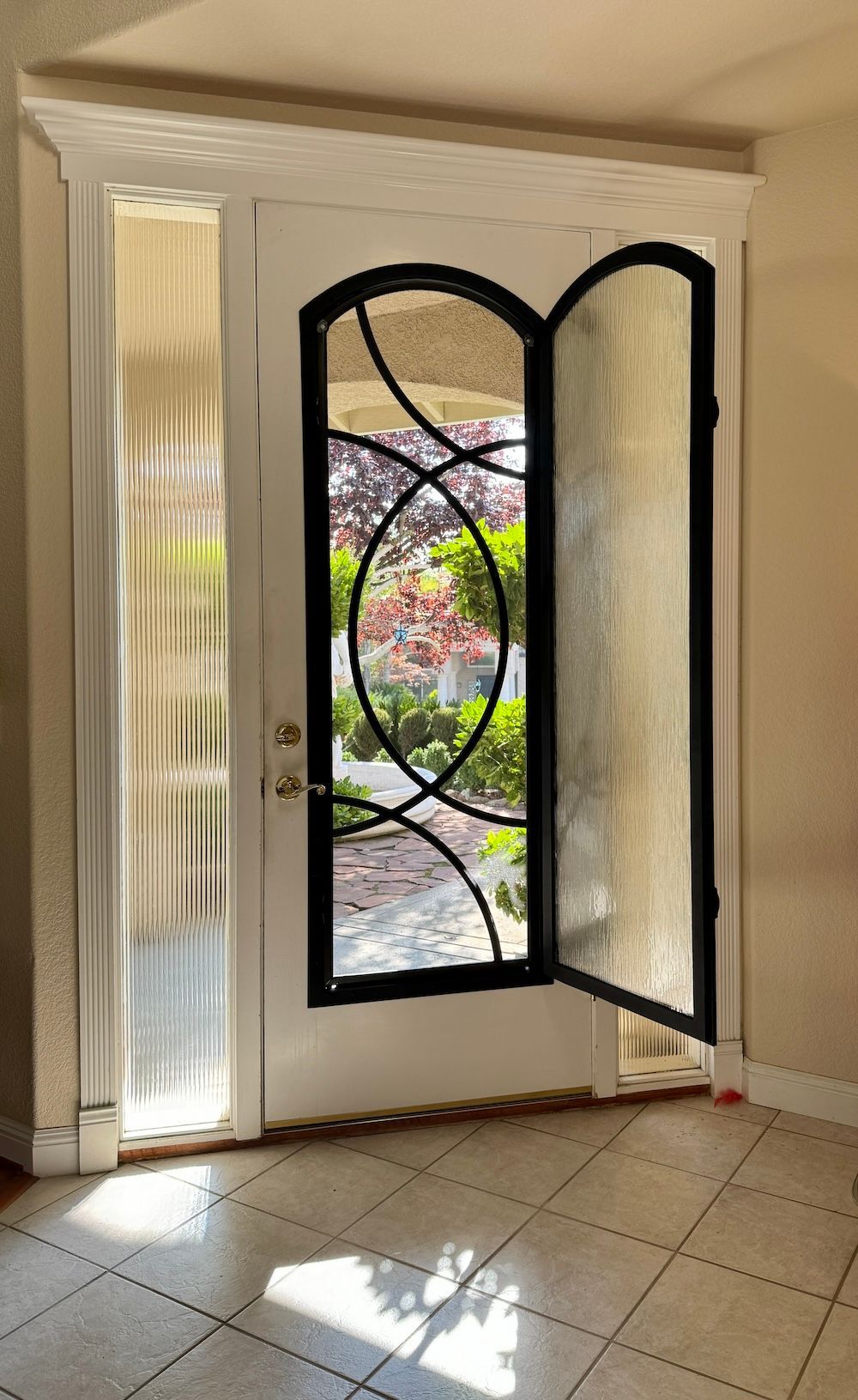 A white door with a black frame and a stained glass window.
