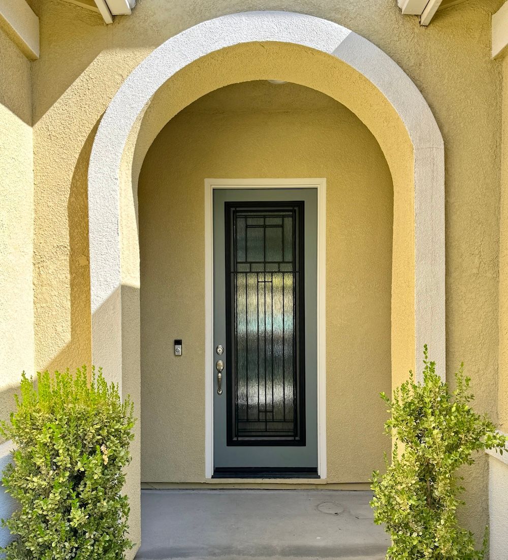 The front door of a house with a wrought iron gate