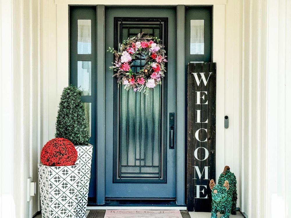 A front door with a wreath on it and a welcome sign.
