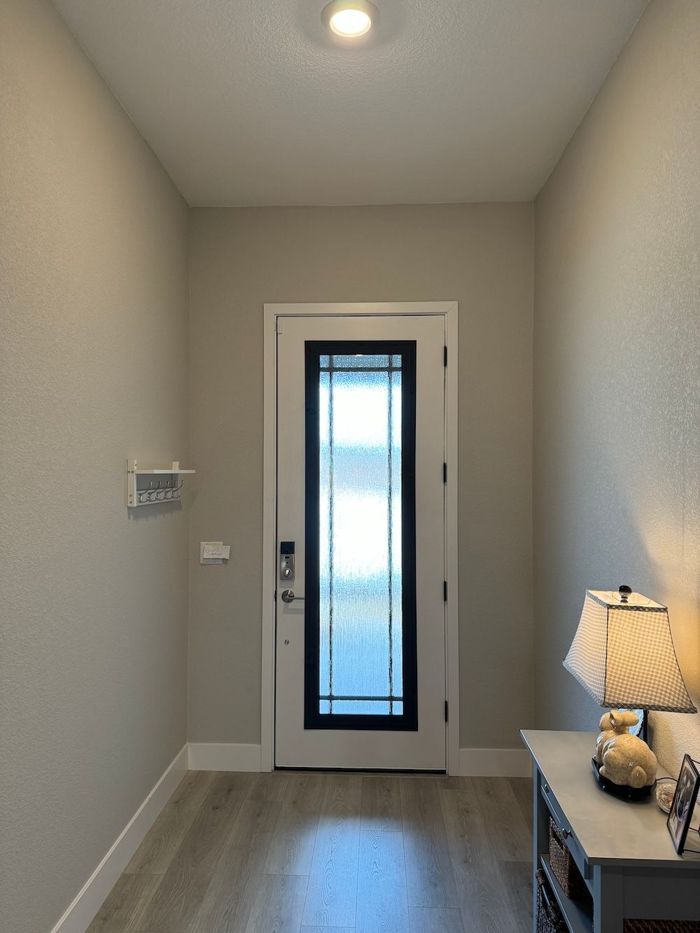 A hallway with a white door and a lamp