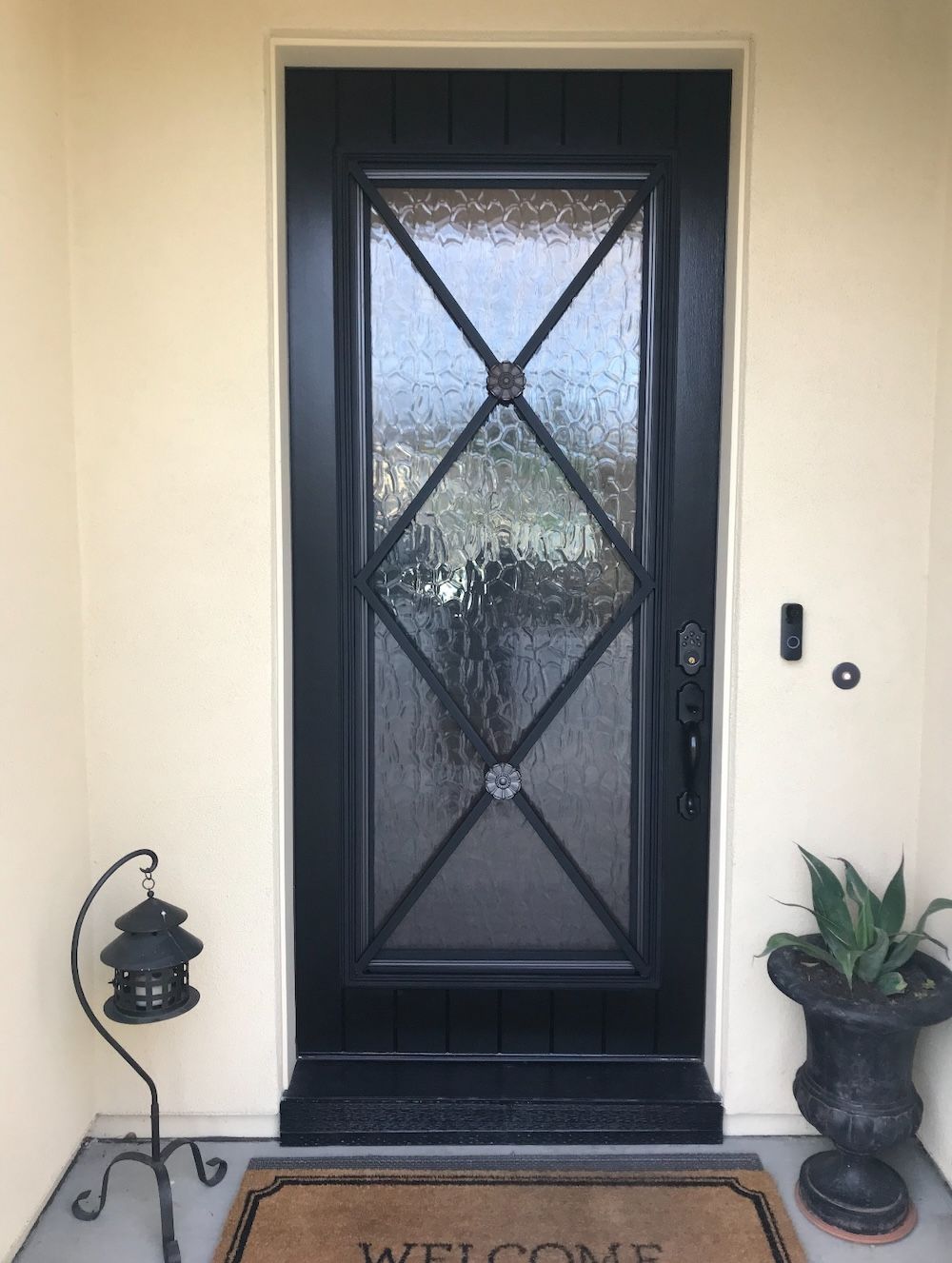 A black door with a welcome mat in front of it