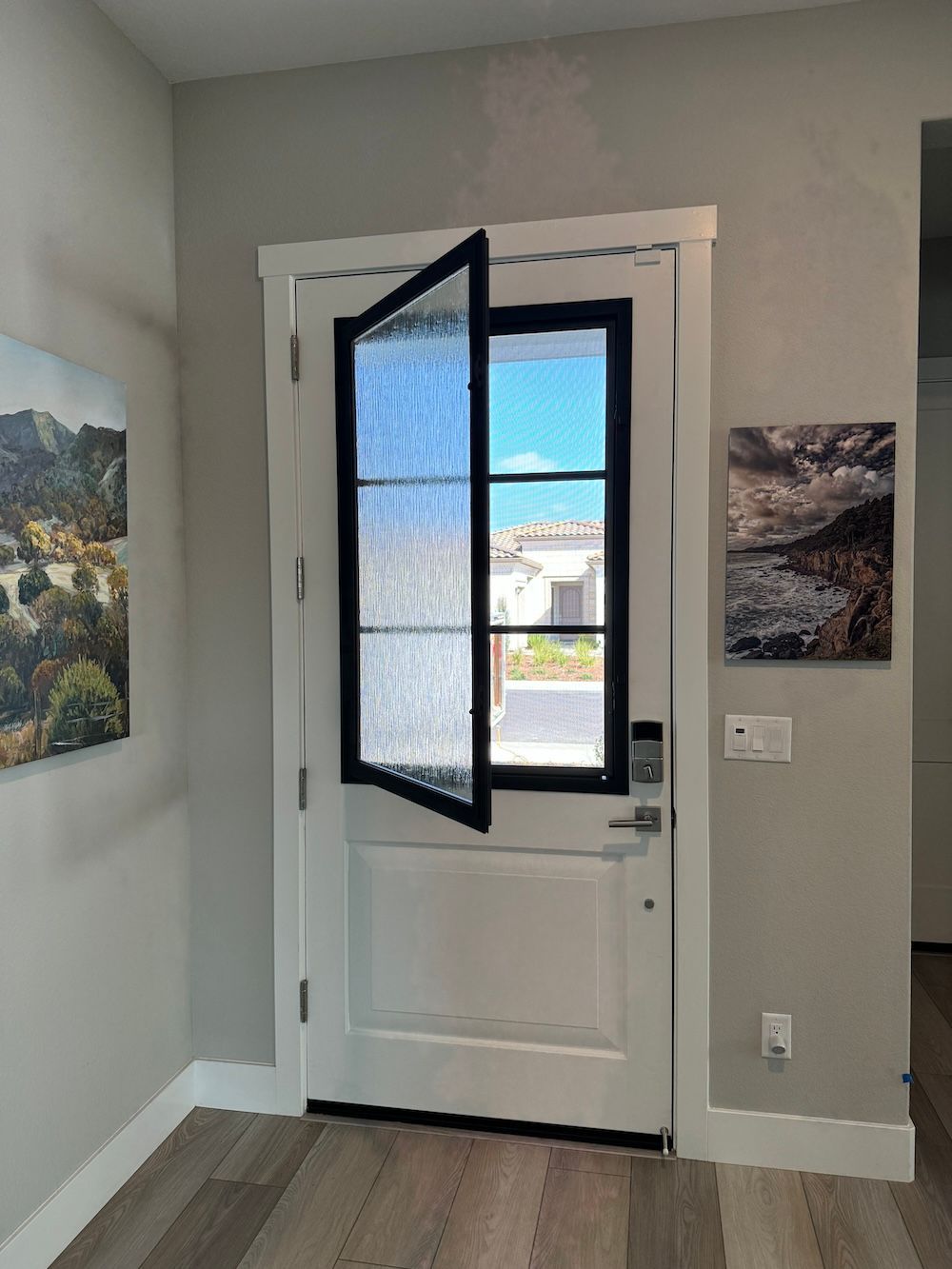 A white door with a black frame and a window in a hallway.