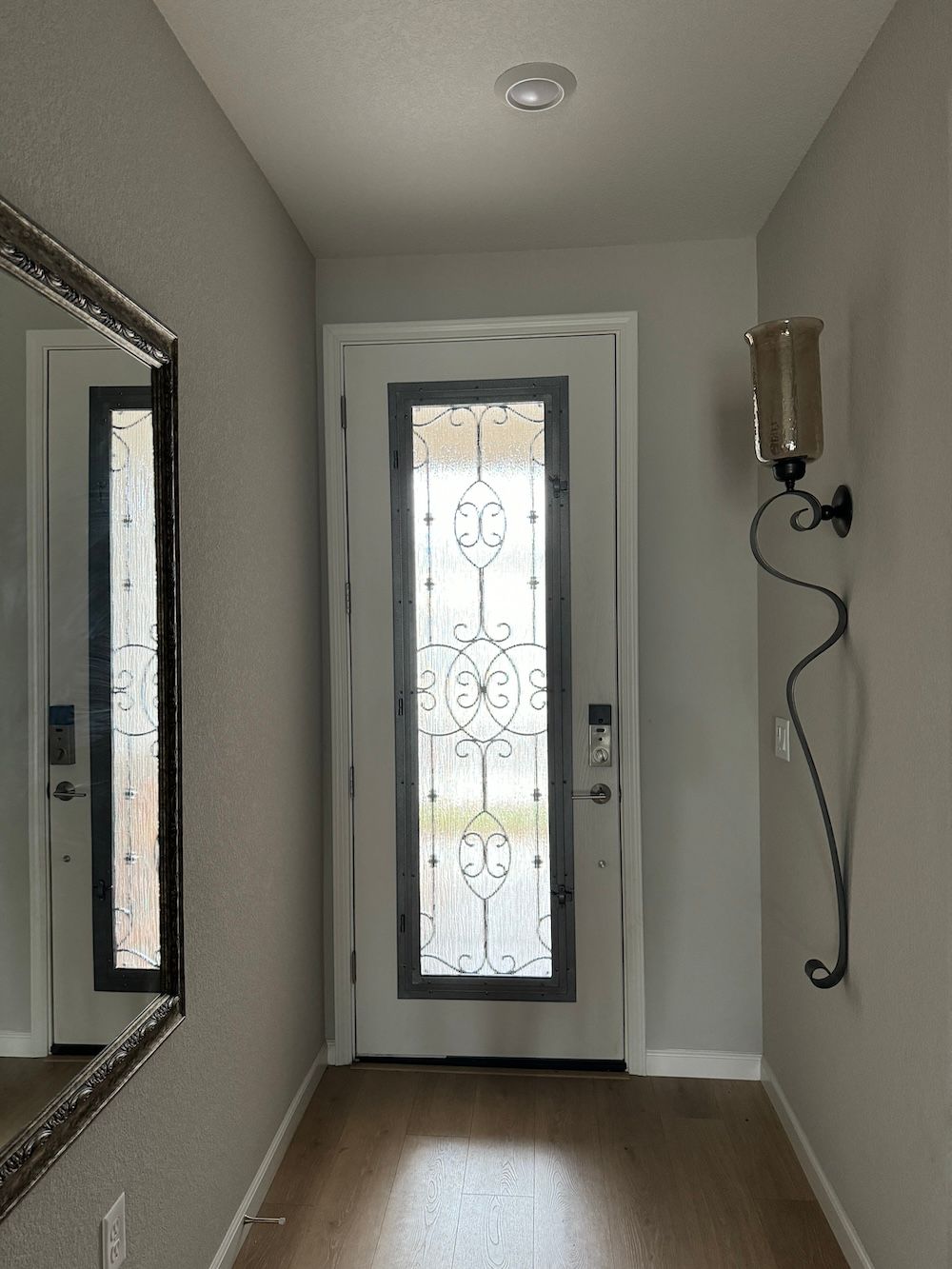 A hallway with a door and a mirror