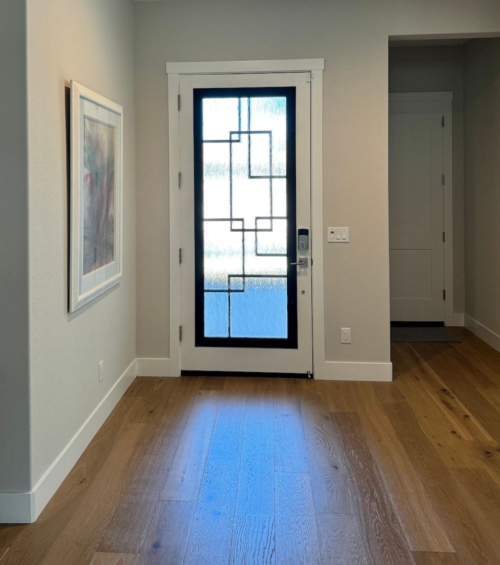 A hallway with a door and a picture on the wall