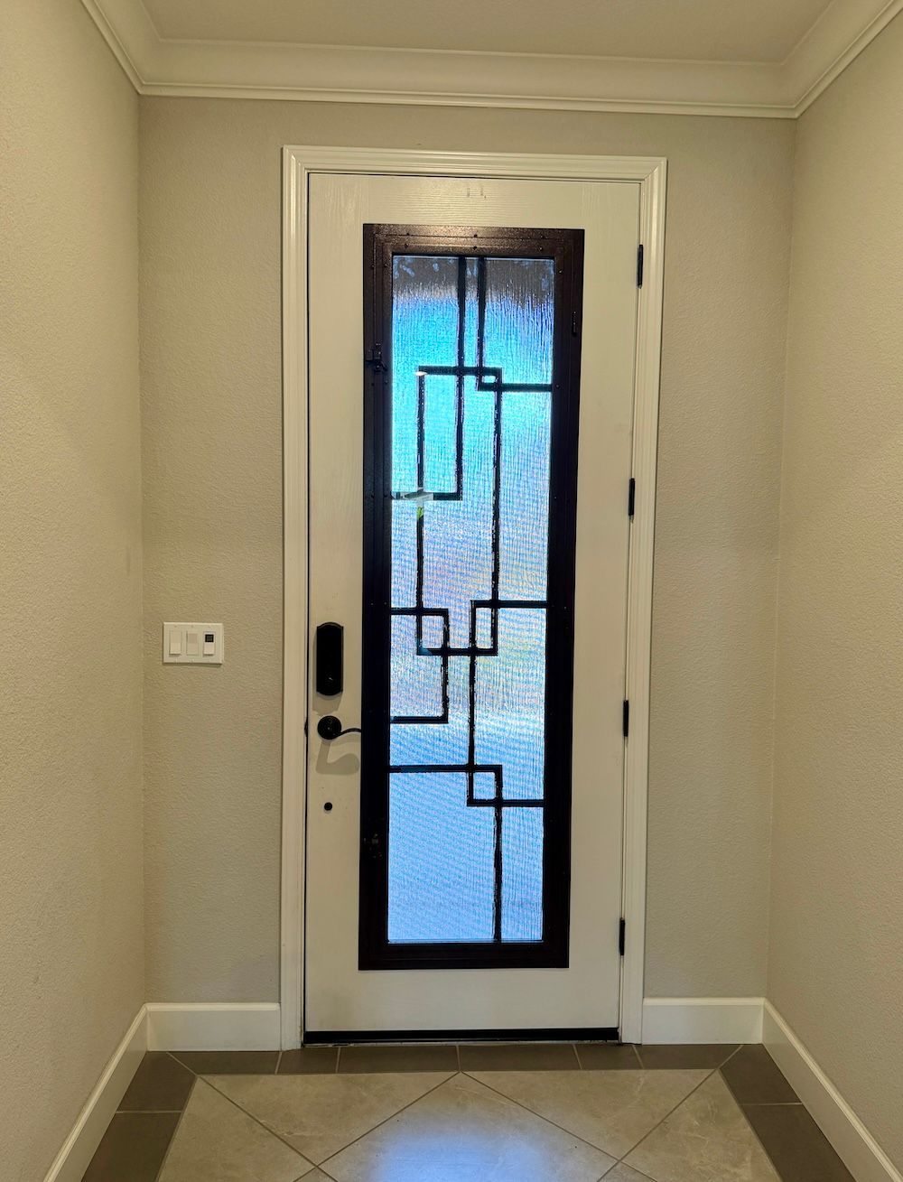 A white door with a black frame is in a hallway.
