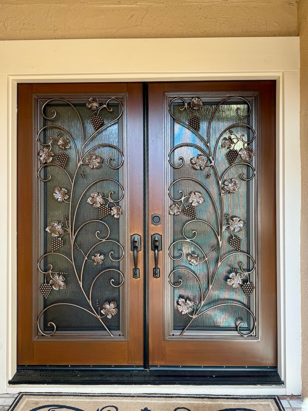 A wooden door with a wrought iron design on it.