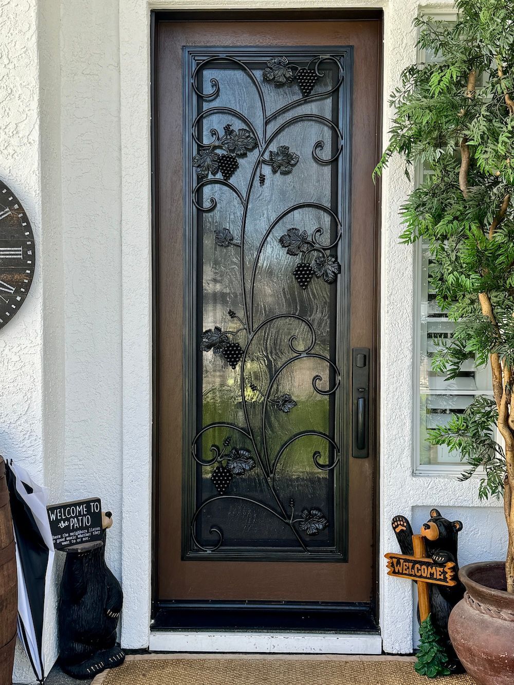 The front door of a house with a wrought iron design on it.