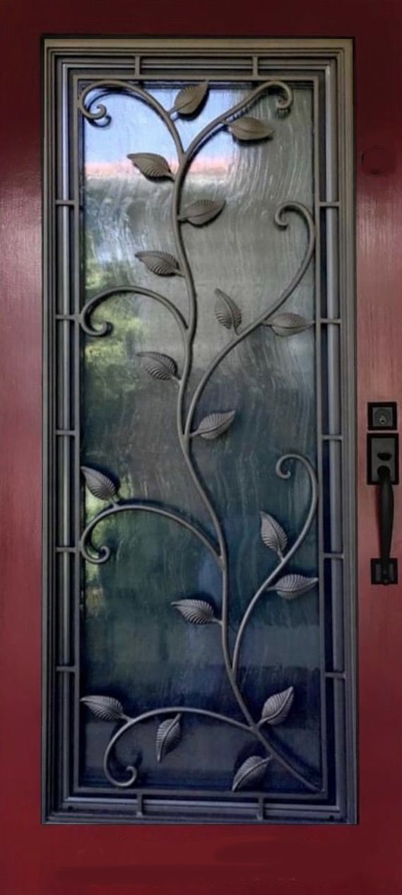 A wrought iron door with a tree design on it.