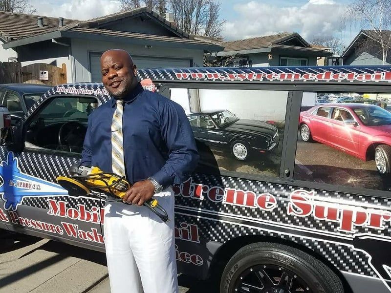 a man standing in front of a car that says extreme super