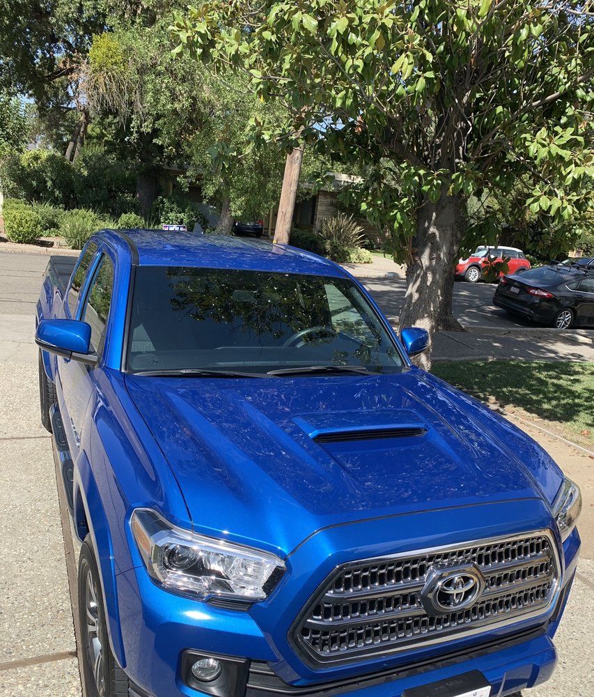 a blue truck is parked on the side of the road