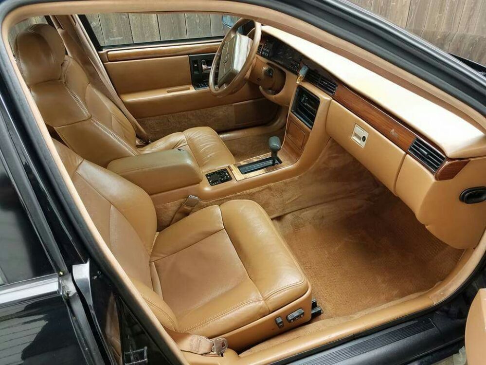 the interior of a black car with tan leather seats