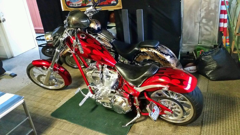 a red motorcycle is parked on a green mat in a garage