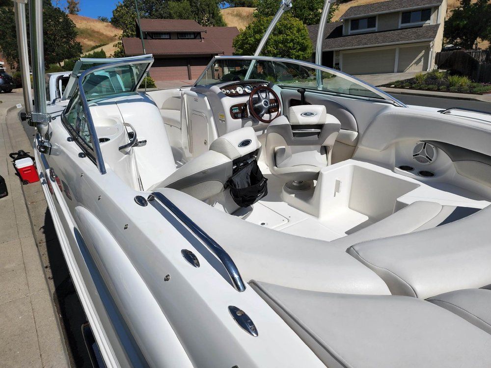 a white boat is parked on the side of the road